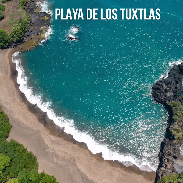 Vista aérea de una playa en la región de Los Tuxtlas, Veracruz, destacando formaciones rocosas de origen volcánico, arena oscura, mar turquesa y vegetación selvática que llega hasta la costa.