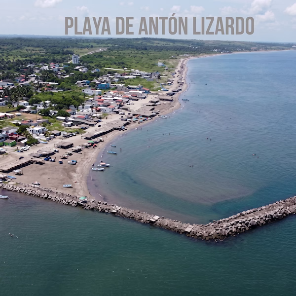 Vista aérea de la Playa de Antón Lizardo en Veracruz, mostrando el rompeolas de piedra, aguas tranquilas ideales para nadar y la zona de palapas turísticas en la costa.