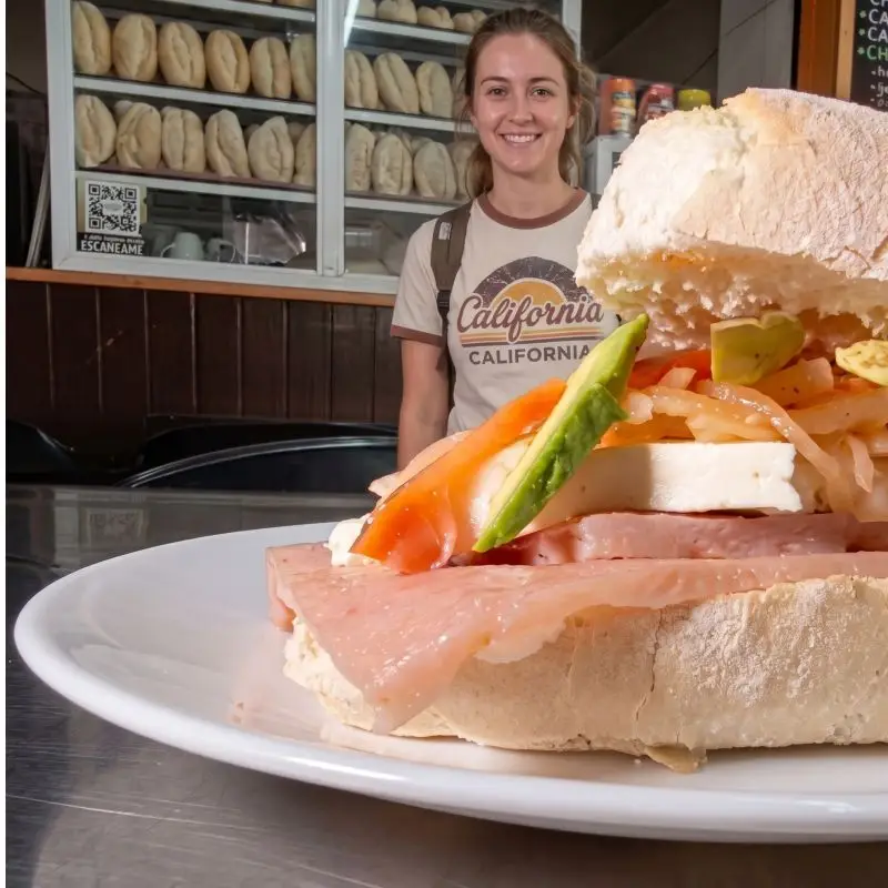 La tradicional torta de cueritos en primer plano con una turista sonriendo en una panadería de Gutiérrez Zamora, Veracruz.