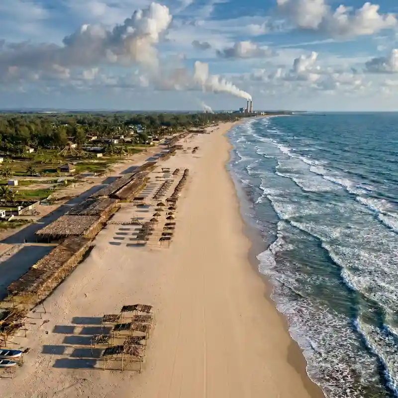 Vista aérea con dron de las extensas playas de Tuxpan Veracruz, mostrando la línea de palapas tradicionales sobre la arena dorada y el oleaje suave del mar.
