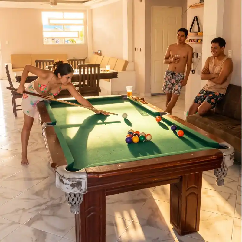 Grupo de amigos disfrutando de la mesa de billar en las áreas sociales de Viddazul Casa Vacacional Costa Esmeralda