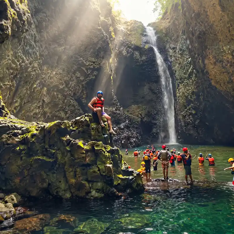 Turistas haciendo ecoturismo y disfrutando de la Cascada El Encanto en la ruta de aventura hacia Costa Esmeralda.