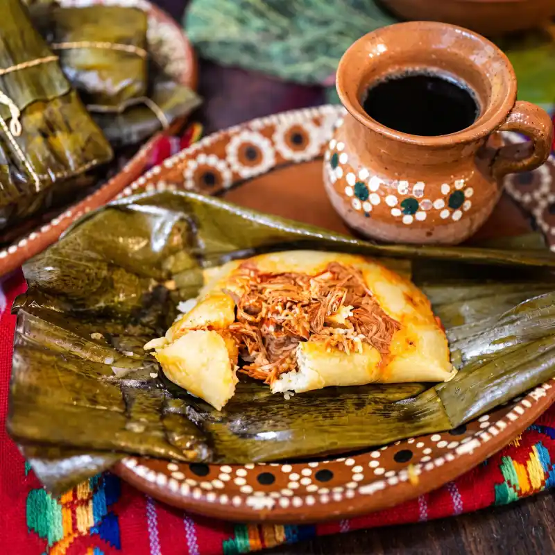 Desayuno típico de la sierra con tamales veracruzanos y café de barro caliente en la Ruta Puebla a Costa Esmeralda.