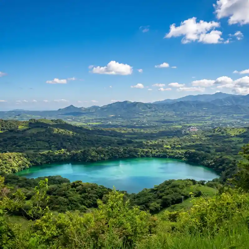 Vista panorámica de la Laguna Encantada con aguas turquesas dentro de un cráter, rodeada de selva y montañas en San Andrés Tuxtla, ideal para el ecoturismo y aventura en Veracruz.