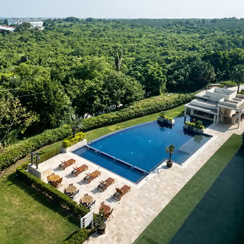 Vista aérea de la amplia alberca y exuberantes áreas verdes en La Quinta by Wyndham Poza Rica, ofreciendo un entorno de total tranquilidad para huéspedes corporativos de larga estancia.