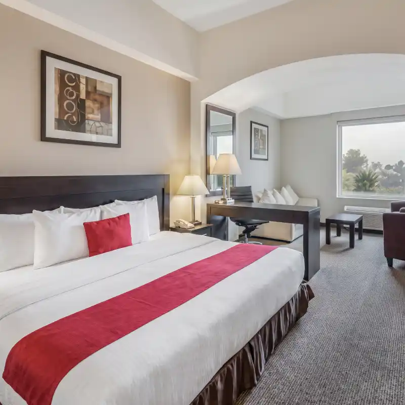Amplia habitación accesible ADA con cama King size en el Hotel La Quinta by Wyndham Poza Rica, diseñada con pasillos abiertos y mobiliario adaptado para facilitar la movilidad.