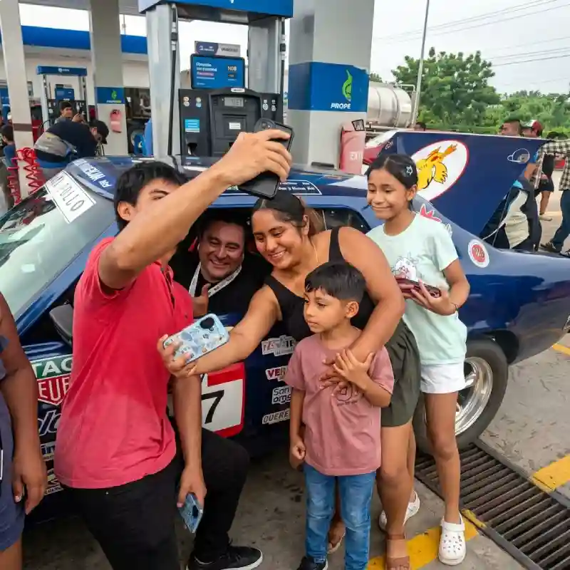 Familia veracruzana tomándose una selfie con piloto de rally en la Carrera Panamericana