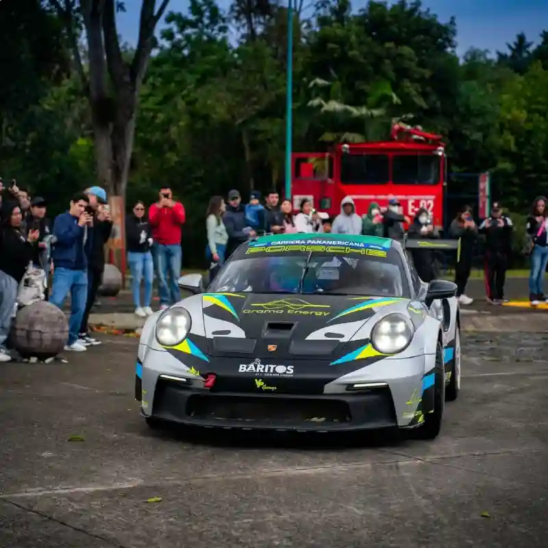 Auto deportivo de competencia rodeado de espectadores durante la exhibición en la macroplaza y el malecón en La Carrera Panamericana.