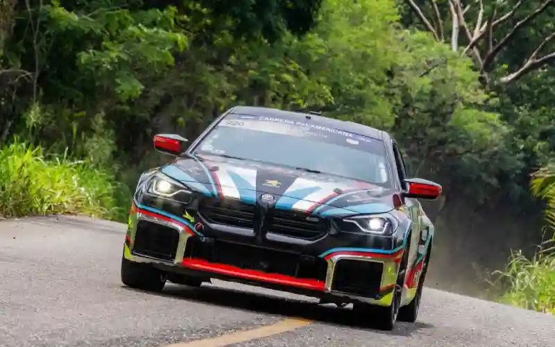 Auto deportivo oscuro tomando una curva de montaña en la Carrera Panamericana en Veracruz