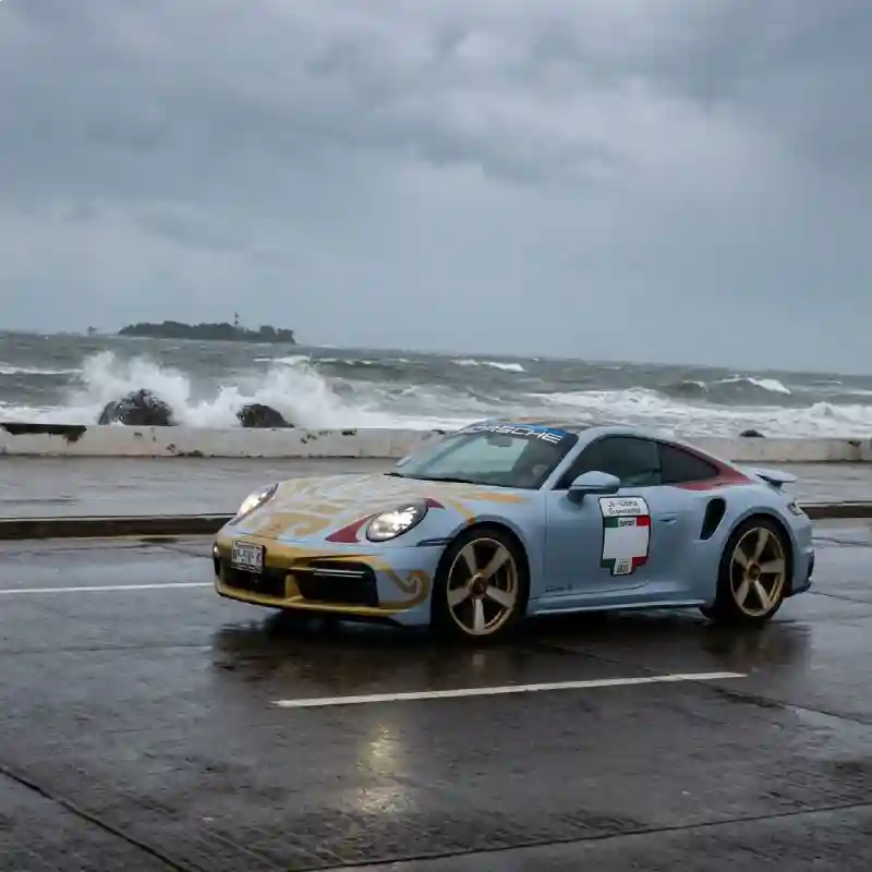 Auto deportivo compitiendo frente al mar y la Isla de Sacrificios en la Carrera Panamericana en Veracruz