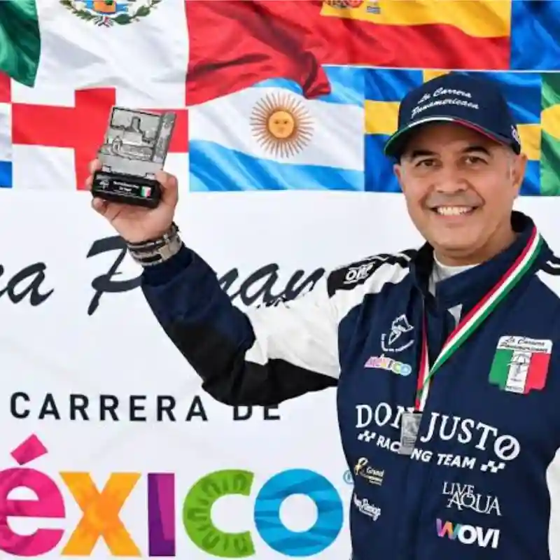 Don Justo, piloto veracruzano de Don Justo Racing Team, sonriendo y sosteniendo un trofeo tras su destacada participación en La Carrera Panamericana.