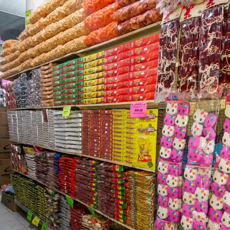 Anaqueles repletos de botanas, cajas de dulces y chicles exhibidos en Grupo Dulcelandia Papantla para pedidos por WhatsApp.