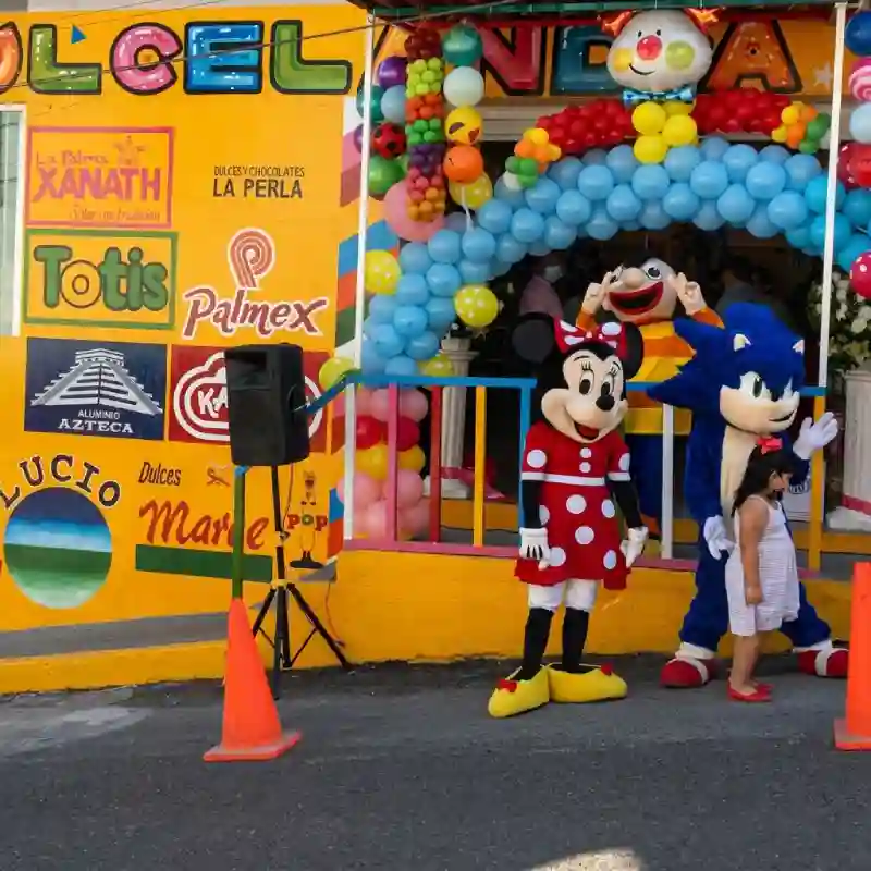 Fachada decorada de Grupo Dulcelandia Sucursal Artes en Papantla con arcos de globos y botargas infantiles.