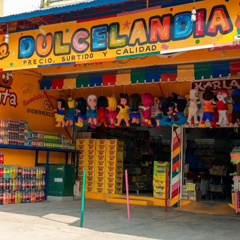 Entrada y fachada de Grupo Dulcelandia Sucursal 5 de Mayo en el centro de Papantla con piñatas y refrescos en exhibición.