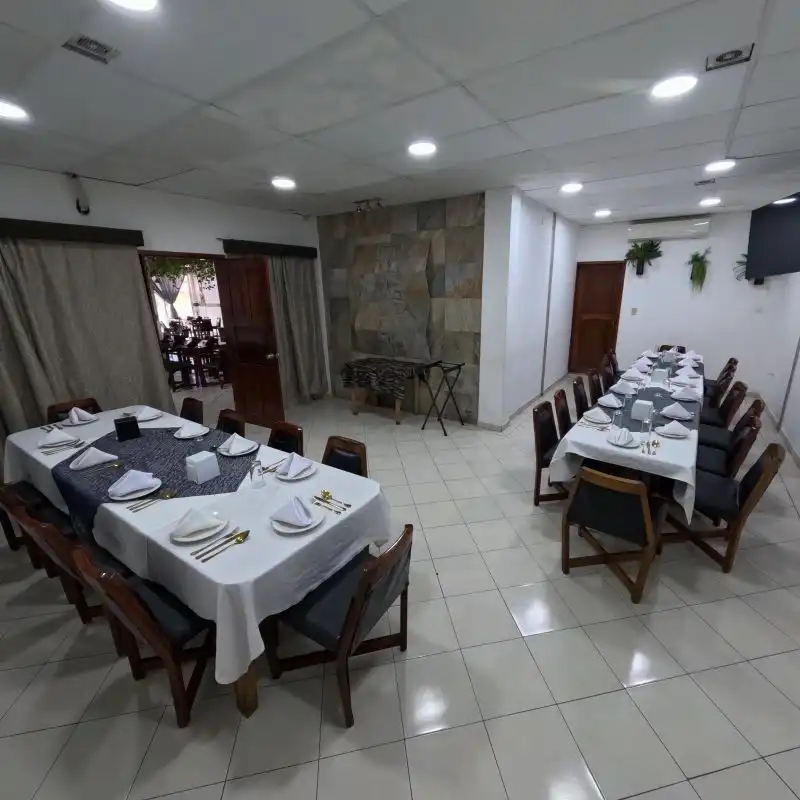 Salón privado y climatizado con mesas largas elegantemente preparadas para eventos y reuniones familiares en Restaurante Moyo, Martínez de la Torre.