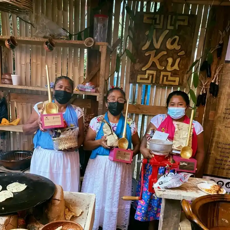 Cocineras tradicionales del colectivo Mujeres de Humo sosteniendo reconocimientos y trofeos gastronómicos en Restaurante Nakú, baluarte del Alma Totonaca en Explora Veracruz.