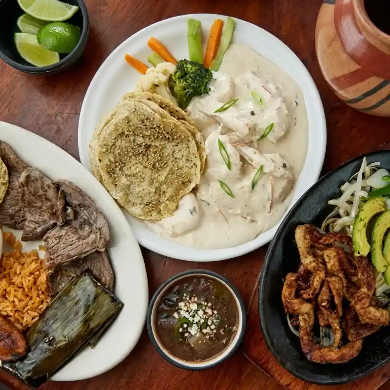 Variedad de platillos papantecos incluyendo empipianadas, pechuga en salsa cremosa, fajitas y carne asada en Restaurante Nakú, muestra gastronómica del Alma Totonaca en Explora Veracruz.