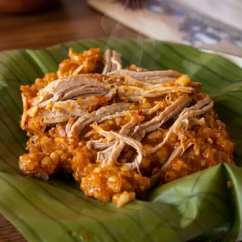 Zacahuil Folclórico tradicional horneado durante toda la noche en hojas de platanillo con masa martajada, chile ancho y pulpa de cerdo jugosa en Restaurante Nakú, especialidad del Alma Totonaca en Explora Veracruz.