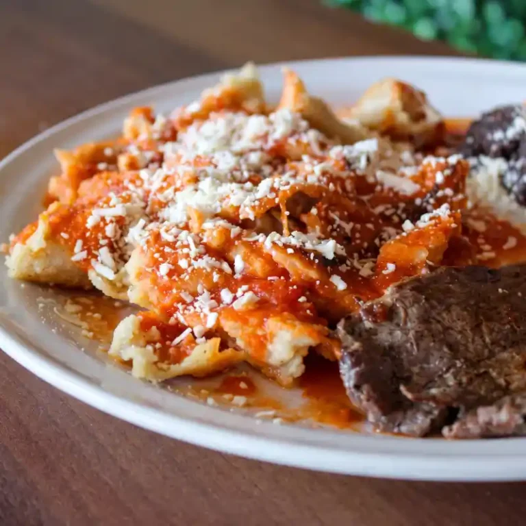 Plato de estrujadas tradicionales totonacas bañadas en salsa roja casera con queso fresco espolvoreado y cecina de la sierra en el Restaurante Plaza Pardo en Papantla.